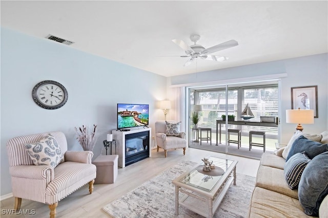 living room featuring ceiling fan and light hardwood / wood-style floors