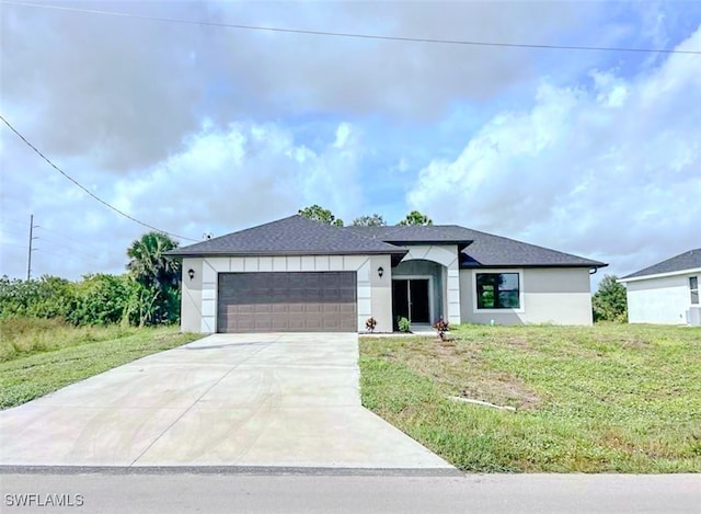 view of front of home with a front yard and a garage