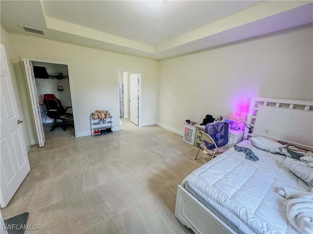 bedroom featuring a raised ceiling and light colored carpet