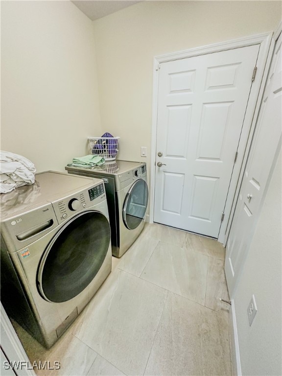 laundry room featuring light tile patterned floors and washer and dryer