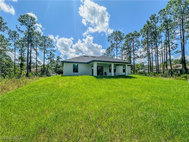 rear view of property featuring a yard