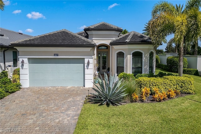 mediterranean / spanish-style home with a garage and a front lawn