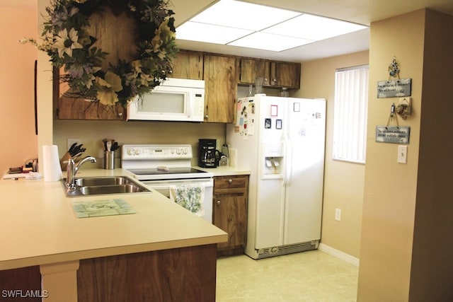 kitchen with kitchen peninsula, sink, and white appliances