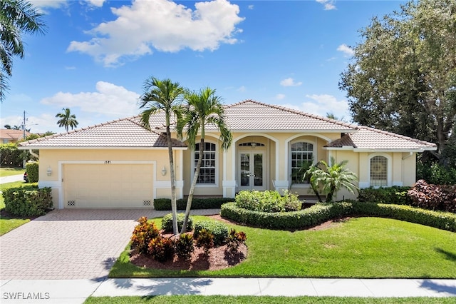 mediterranean / spanish home with a garage and a front yard