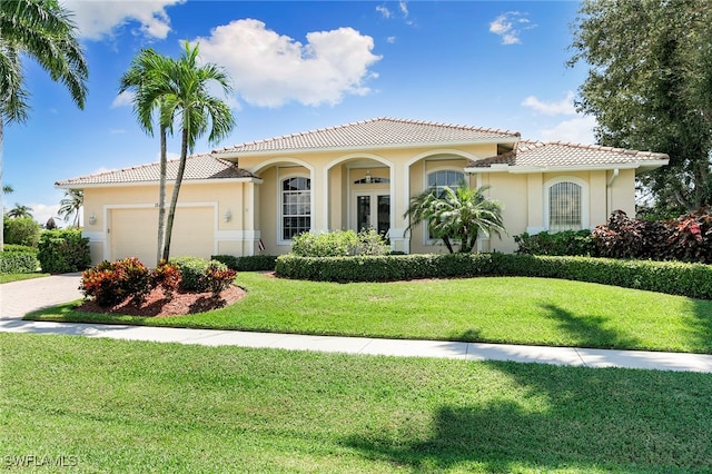 mediterranean / spanish-style house featuring a front yard and a garage