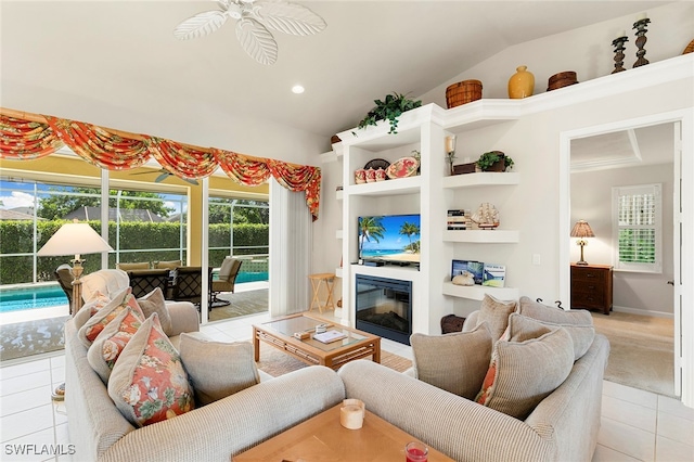 living room with vaulted ceiling, ceiling fan, and light tile patterned floors