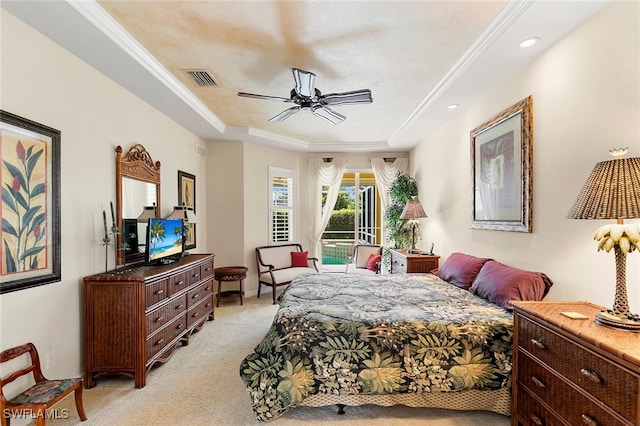 bedroom with crown molding, a tray ceiling, light carpet, and ceiling fan