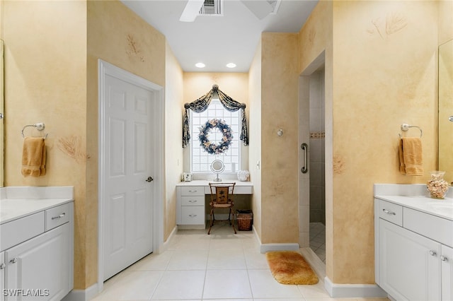 bathroom with vanity, a tile shower, and tile patterned floors