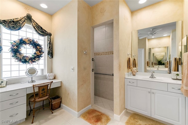 bathroom with a tile shower, tile patterned flooring, ceiling fan, and vanity