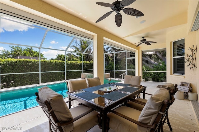 sunroom with lofted ceiling, ceiling fan, and a healthy amount of sunlight