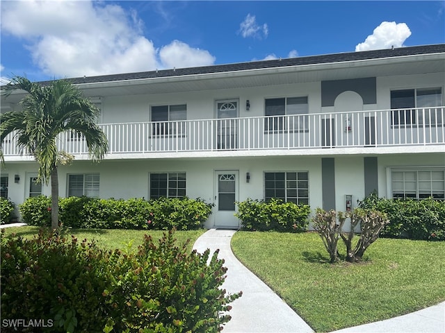 exterior space featuring a balcony and a front yard