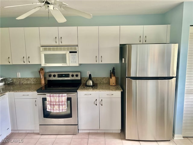 kitchen with appliances with stainless steel finishes, light stone counters, and white cabinetry