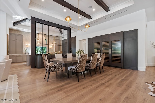 dining room with beam ceiling, a towering ceiling, and light hardwood / wood-style flooring