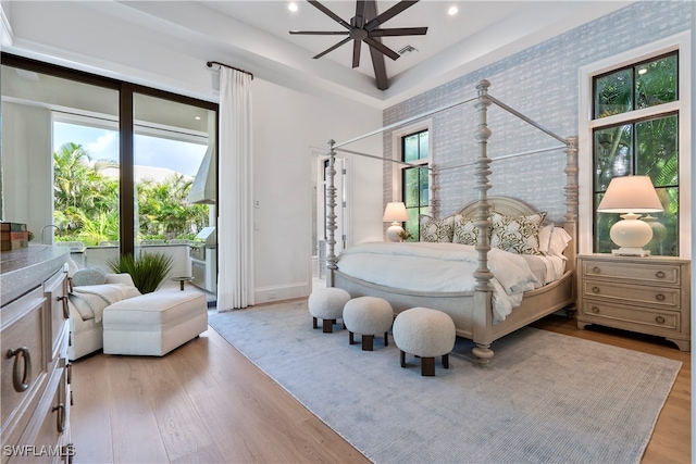 bedroom with light wood-type flooring, multiple windows, and ceiling fan