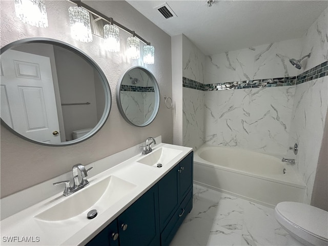 full bathroom featuring tiled shower / bath, vanity, and toilet