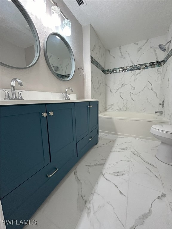 full bathroom with a textured ceiling, vanity, toilet, and tiled shower / bath combo