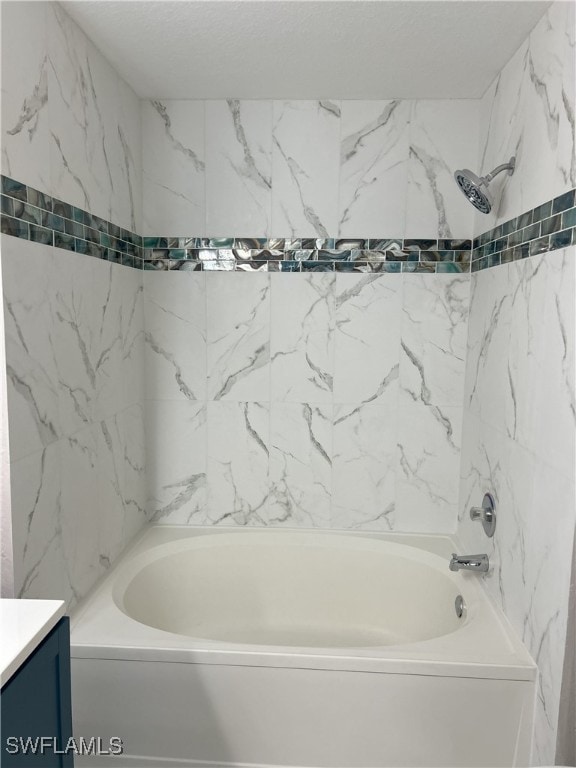 bathroom featuring vanity and tiled shower / bath