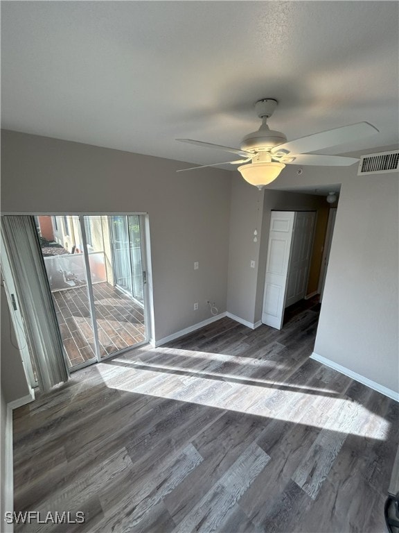 unfurnished room with dark wood-type flooring and ceiling fan