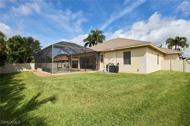 back of house featuring a yard and a lanai