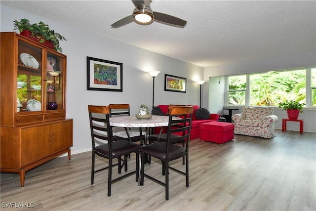 dining space featuring a textured ceiling, ceiling fan, and light hardwood / wood-style flooring