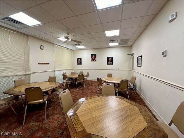 dining space with ceiling fan and a paneled ceiling