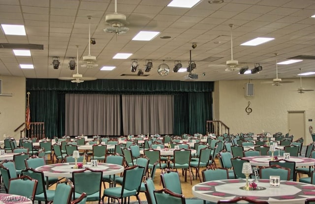 interior space with ceiling fan and a drop ceiling