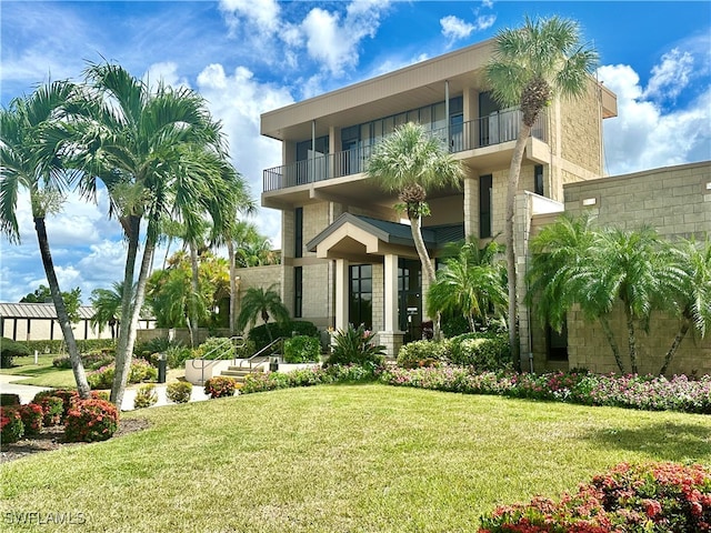 exterior space with a front yard and a balcony