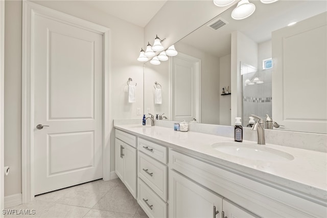 bathroom with a shower, tile patterned flooring, and vanity