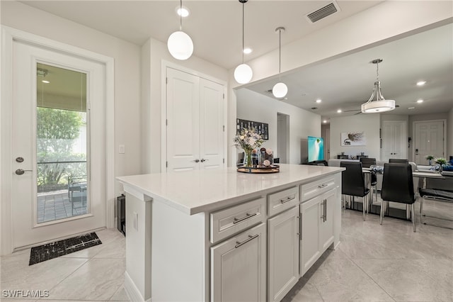 kitchen with white cabinetry, a center island, and decorative light fixtures