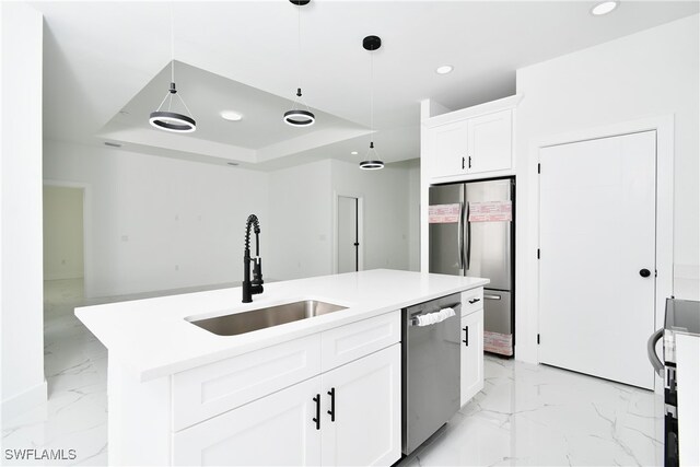 kitchen with decorative light fixtures, a center island with sink, stainless steel appliances, sink, and white cabinets