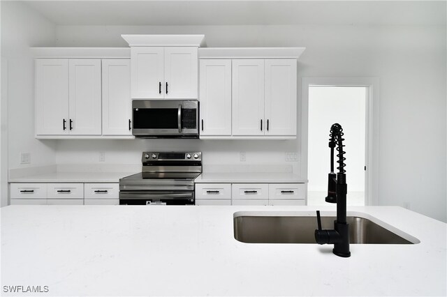 kitchen featuring white cabinetry, stainless steel appliances, and sink