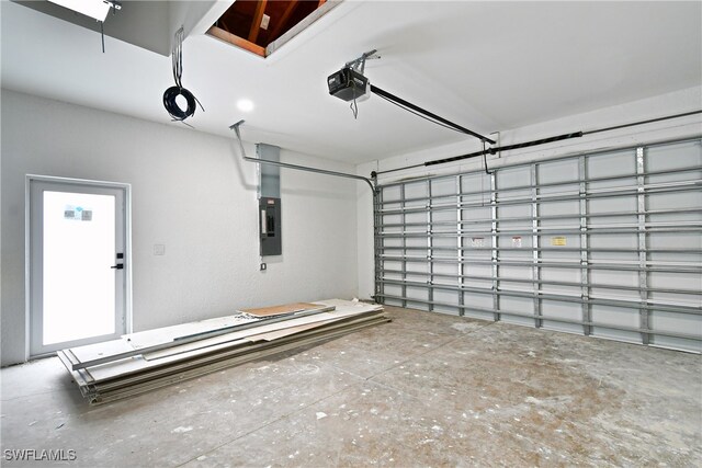 garage with a garage door opener and electric panel