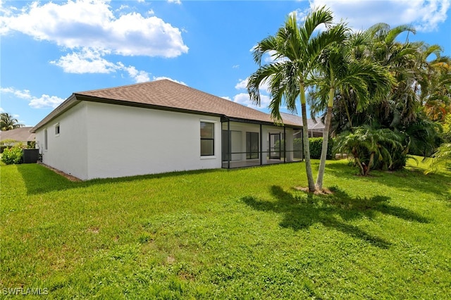 back of property with a yard, cooling unit, and a sunroom