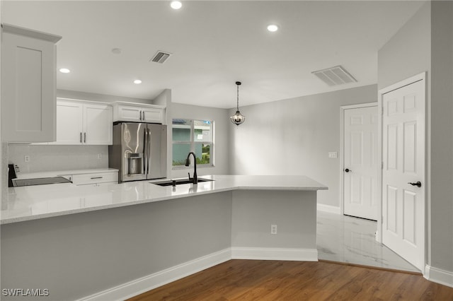 kitchen featuring white cabinetry, light hardwood / wood-style flooring, kitchen peninsula, sink, and stainless steel refrigerator with ice dispenser