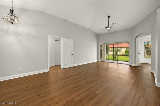 unfurnished living room with vaulted ceiling, ceiling fan with notable chandelier, and dark hardwood / wood-style flooring