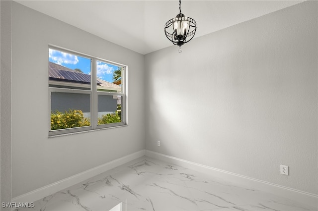 unfurnished room featuring an inviting chandelier