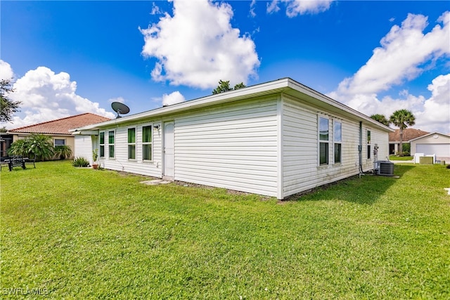 view of property exterior featuring central air condition unit and a yard