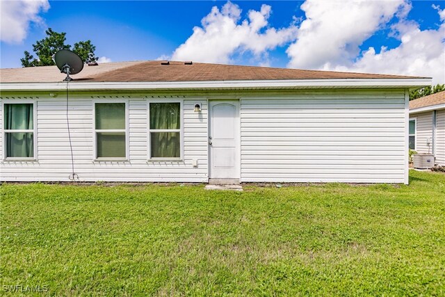 back of house featuring a yard and cooling unit