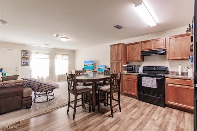 kitchen with light hardwood / wood-style flooring and black range with electric stovetop