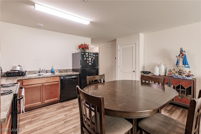 dining room featuring sink and light hardwood / wood-style floors