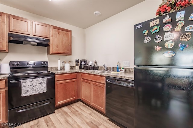 kitchen featuring black appliances, light hardwood / wood-style floors, and sink