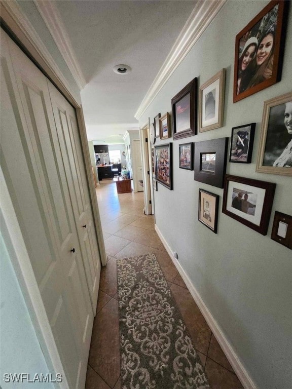 hallway featuring light tile patterned floors and crown molding