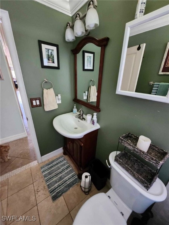 bathroom with crown molding, toilet, tile patterned flooring, and vanity