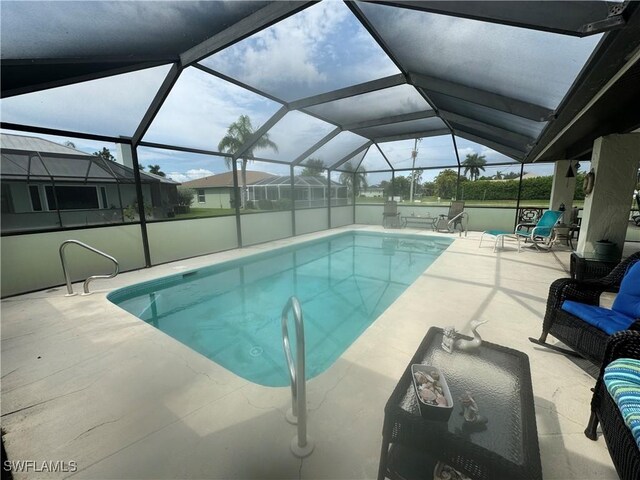 view of pool with glass enclosure and a patio