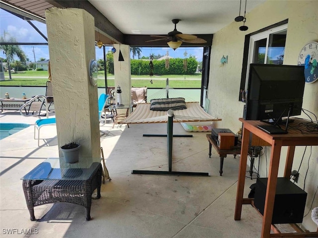 view of patio featuring ceiling fan and a lanai