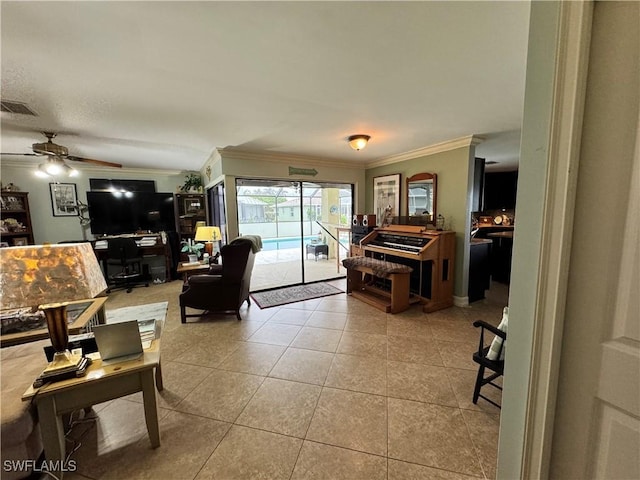 living room with light tile patterned floors, ceiling fan, and ornamental molding