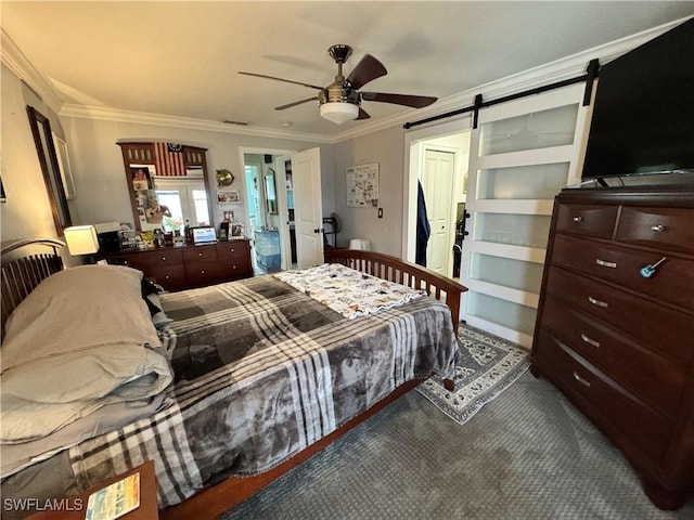 bedroom with crown molding, ceiling fan, and a barn door