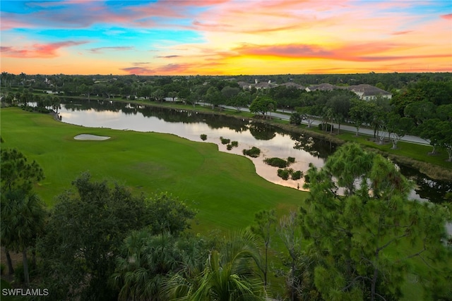 aerial view at dusk featuring a water view