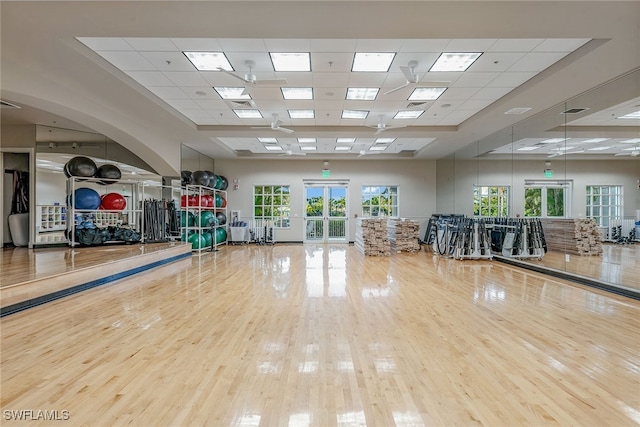 exercise room featuring a drop ceiling, hardwood / wood-style flooring, and french doors