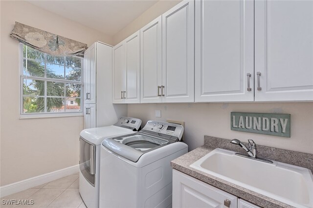 laundry area with light tile patterned floors, cabinets, sink, and washing machine and dryer